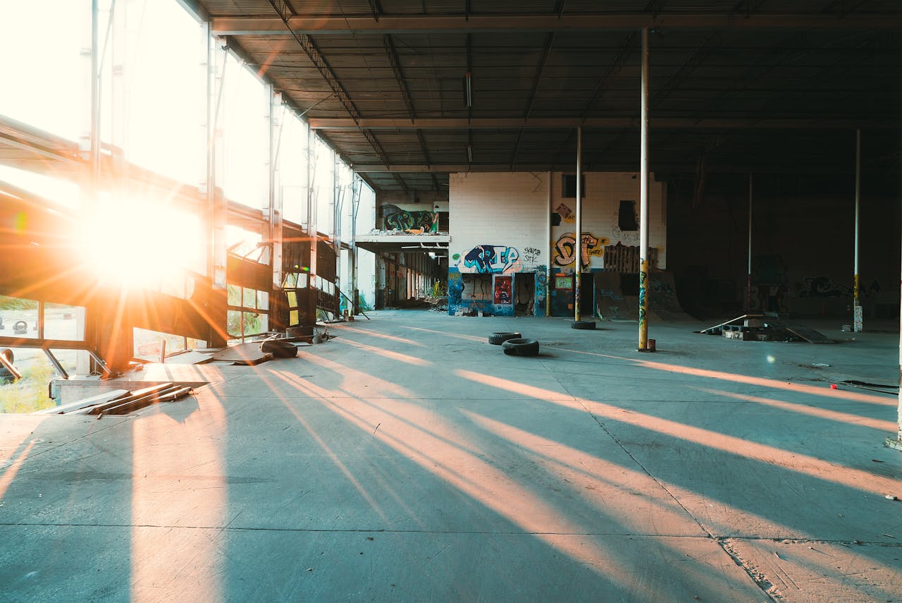 why-choose-us An abandoned warehouse interior with graffiti art and glowing sunlight streaming in.